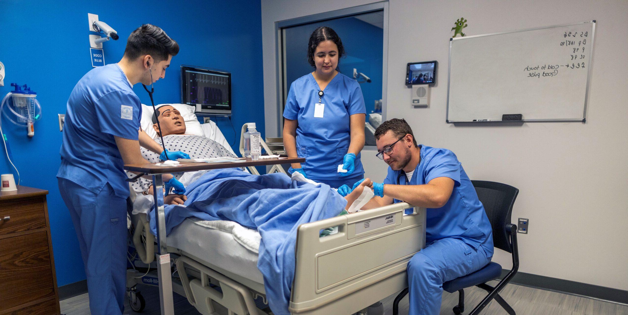 Nursing students practice patient care on a manikin.